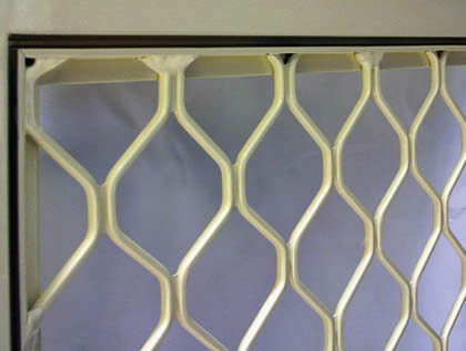 Aluminum diamond grill with silver anodized installed to a window
